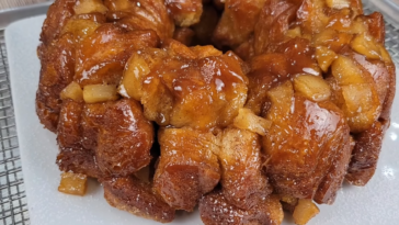 Easy Apple Monkey Bread with gooey cinnamon sugar glaze on a white plate.